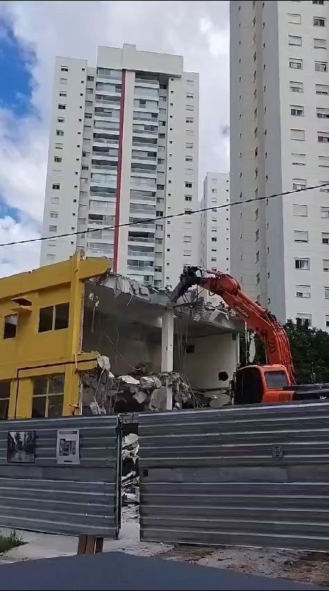 Escavadeira hidráulica demolindo a laje do pavimento superior