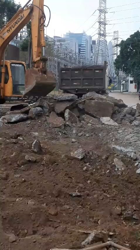 Escavadeira carregando o caminhão com o entulho da demolição